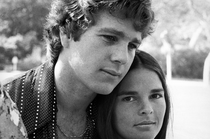 Ryan O Neal, Ali MacGraw | Igralca je med zvezde izstrelil film Ljubezenska zgodba režiserja Arthurja Hillerja, posnet po istoimenskem romanu Ericha Segala, v katerem je upodobil študenta Harvarda, ki se zaljubi v študentko iz delavskega razreda (Ali MacGraw). Dramo je Ameriški filmski inštitut uvrstil med deset najbolj romantičnih filmov vseh časov. | Foto Guliverimage