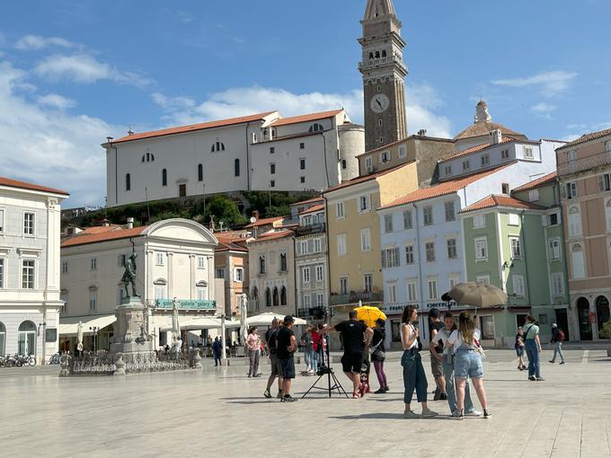 Igralci na varnem v senci, da jih ne opeče sonce, medtem ko čakajo na postavitev scene pred Tartinijevim kipom. | Foto: Igor Harb