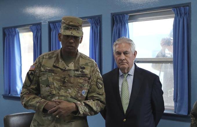 Ameriški državni sekretar je pred tedni obiskal Južno Korejo. Srečal se je tudi z ameriškimi vojaki, ki Južni Koreji pomagajo pri nadzoru meje med obema Korejama. Na fotografiji sta Tillerson in ameriški general Vincent K. Brooks v Panmundžomu, kjer poteka meja s Severno Korejo. V ozadju je severnokorejski vojak, ki skozi okno fotografira Tillersona in Brooksa. | Foto: Reuters