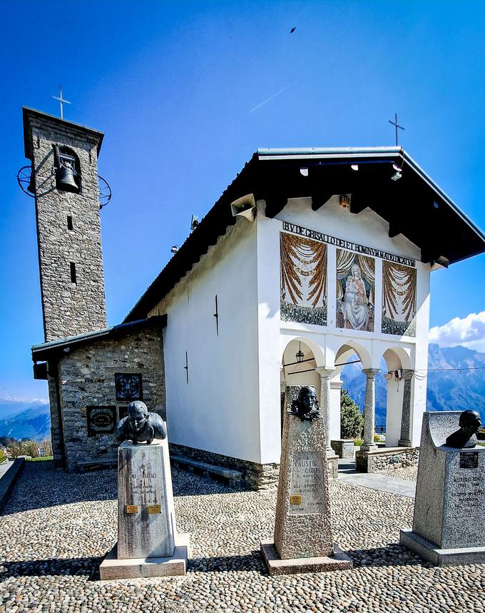 Vhod v kapelo Madonna del Ghisallo krasi vrsta doprsnih kipov, med katerimi izstopata znani kolesarski imeni Fausto Coppi, ki je petkrat zmagal na Giru, in Gino Bartali, ki se je v kolesarsko zgodovino vpisal s tremi zmagami v generalni razvrstitvi rožnate pentlje.  | Foto: Alenka Teran Košir