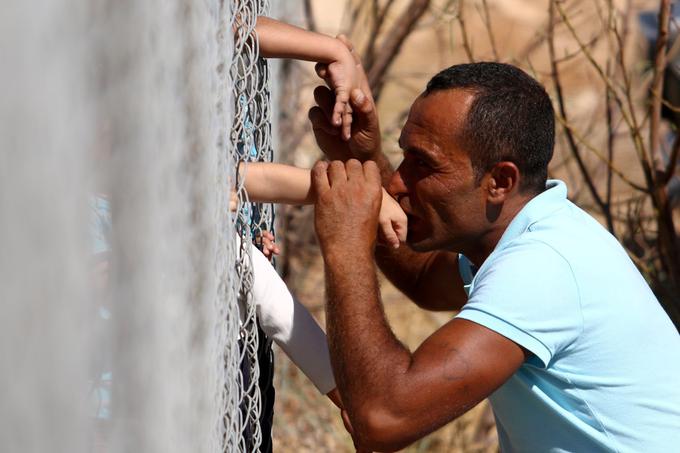 Sirec Ammar Hammasho, ki živi na Cipru, se veseli snidenja s svojimi otroki, ki so prispeli v taborišče za migrante v bližini Nikozije, september 2017.  | Foto: Reuters