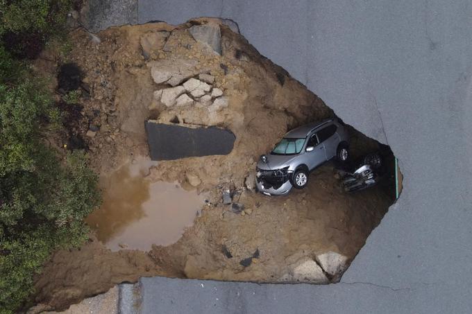 Na ulici v Los Angelesu je vrtača pogoltnila dva avtomobila in ujela dva voznika, ki ju je morala reševati ekipa gasilcev. | Foto: Reuters