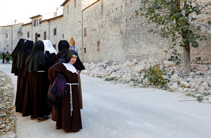 Nune si ogledujejo porušen zid v mestu Norcia, ki ga je potres močno prizadel.  | Foto: Reuters