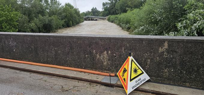 Na starem mostu, ki stoji nekaj sto metrov stran od porušenega mostu na glavni cesti med Črnučami in Litijo, so že postavili nadomestni optični kabel čez še vedno podivjano Kamniško Bistrico. | Foto: Srdjan Cvjetović