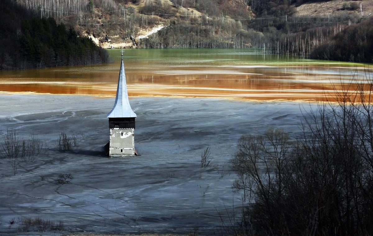 Geamana | Podoba barvitega jezera in cerkvenega zvonika skoraj spominja na slovensko jezero na Bledu, le da je tam mogoče plavati brez strahu, da se bomo zastrupili, v njem pa najdemo tudi kakšno ribo. Romunsko jezero, ki je prekrilo vas Geamana, je medtem mrtvo, vedno bolj pa ogroža tudi celotno regijo. | Foto Reuters