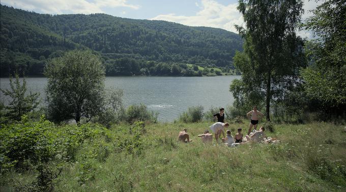 Režiser Jonathan Glazer z neskladnostjo prekrasnih podob presrečne družine v neokrnjeni naravi z grozo koncentracijskega taborišča (v katerega kamera nikoli ne vstopi) vzbudi nelagodje in šokira gledalca. | Foto: Fivia