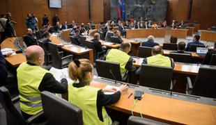 Poslanci SNS oblekli rumene jopiče. Levica: Rumeni jopiči se ne bojujejo proti Marakešu.