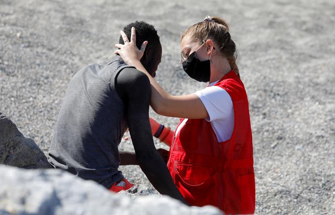 "Jokal je, stegnila sem roko in objel me je," je dejala 20-letna Luna, prostovoljka Rdečega križa, potem ko je po svetu zaokrožila ta fotografija z beguncem iz Senegala. Pod njo se je na družbenih omrežjih usul plaz seksističnih in rasističnih komentarjev. "Takih Lun, ki dnevno pomagajo migrantom v Ceuti, je pri nas ogromno," so odgovorili v španskem Rdečem križu.   | Foto: Reuters