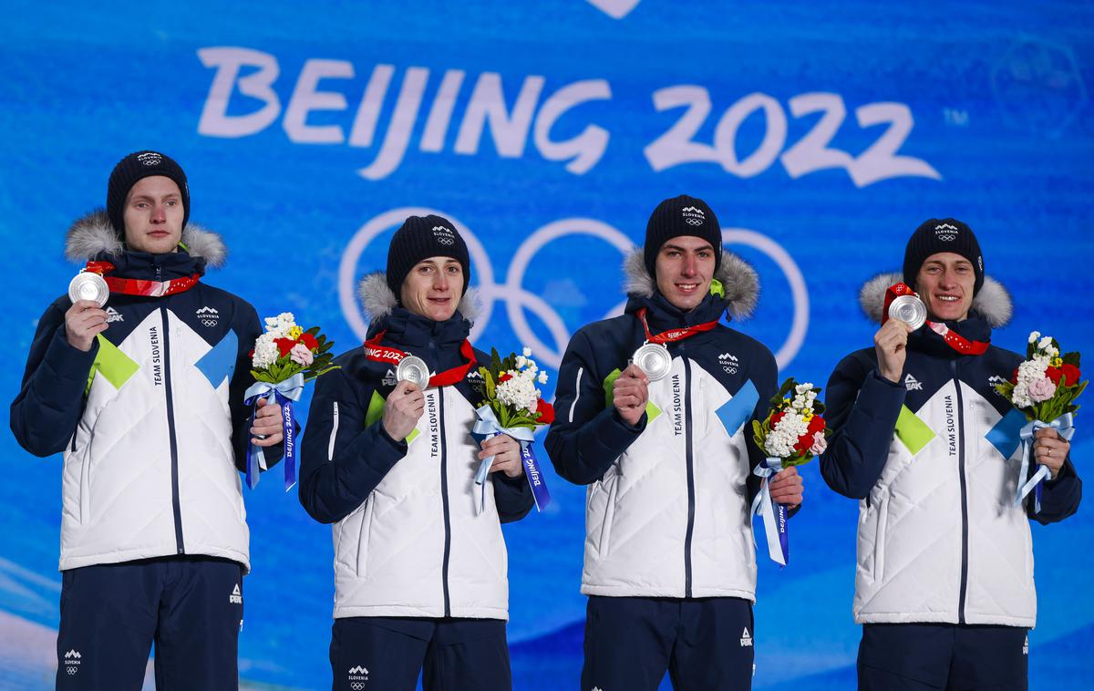 Peking, podelitev medalj, Peter Prevc, Cene Prevc, Timi Zajc, Lovro Kos | Peter Prevc, Cene Prevc, Timi Zajc, Lovro Kos ob prejemu srebrnih "ekipnih" kolajn lani v Pekingu. Moške ekipne tekme na prihodnjih olimpijskih igrah ne bo. Zamenjala jo bo superekipna tekma, na kateri bodo skakali v parih. | Foto Anže Malovrh/STA