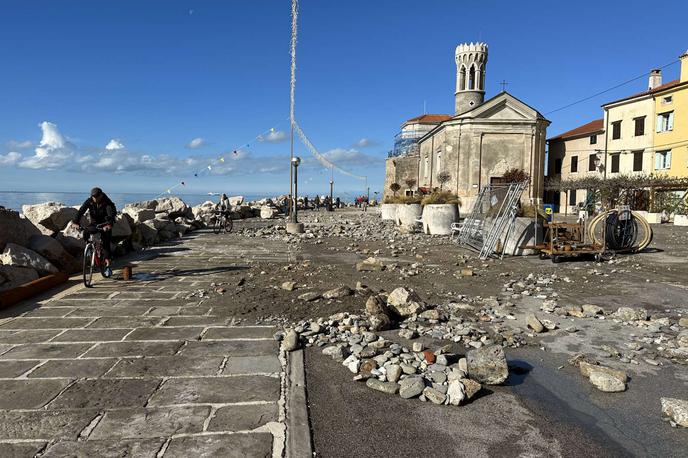 Piran, skale | Že v petek dopoldne je v Piranu zapihal močan veter, zaradi katerega so nastali visoki valovi, ki so uničili obalo. Ogromne skale valobrana je nametalo na cesto, zaradi česar ta dolgo ni bila prevozna, saj se zaradi razmer do nje ni dalo dostopati niti z delovnimi stroji. | Foto STA