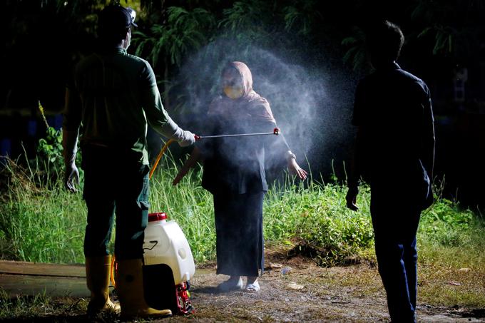 Po pogrebu v Džakarti dezinficirajo tudi sorodnike žrtev. | Foto: Reuters