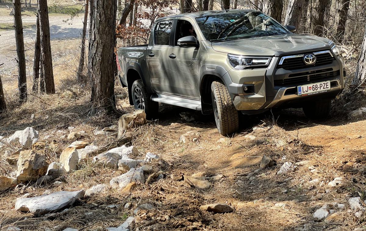 Toyota hilux | Poltovornjak je resda dolg več kot pet metrov in ima tudi več kot tri metre medosne razdalje, toda zanesljiv pogon in oddaljenost od tal (21−33 centimetrov) ga naredita zelo konkurenčnega tudi izven urejenih cest. | Foto Gregor Pavšič