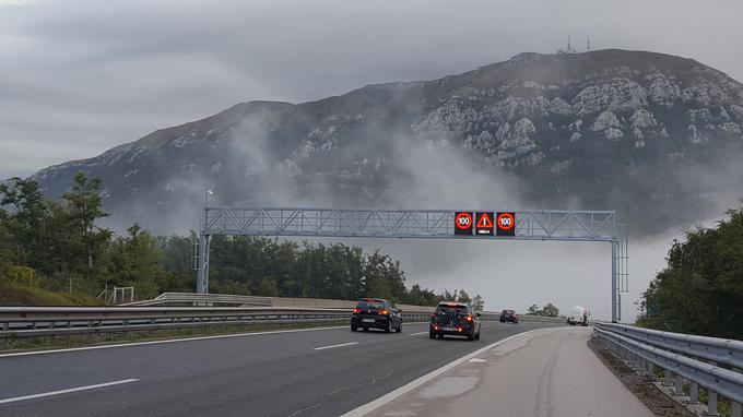 Med Senožečami in Razdrtim so prav zaradi pogoste megle na odseku nad avtocesto namestili nov portal, ob obeh smernih voziščih, na razdalji približno 1,4 kilometra, pa so postavili manjše elektronske signalne table, tudi za opozarjanje na nevarnost megle. | Foto: DARS/zajem zaslona