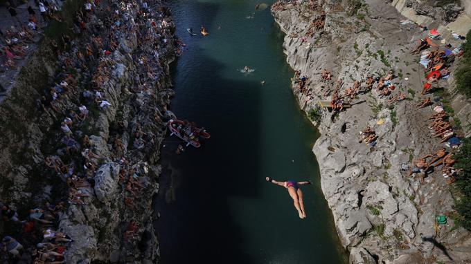 Soča je zaradi zožitve struge v soška korita pod kanalskim mostom mnogo globlja kot na drugih predelih, tako da se skakalci poženejo v približno 11 metrov vode. | Foto: STA