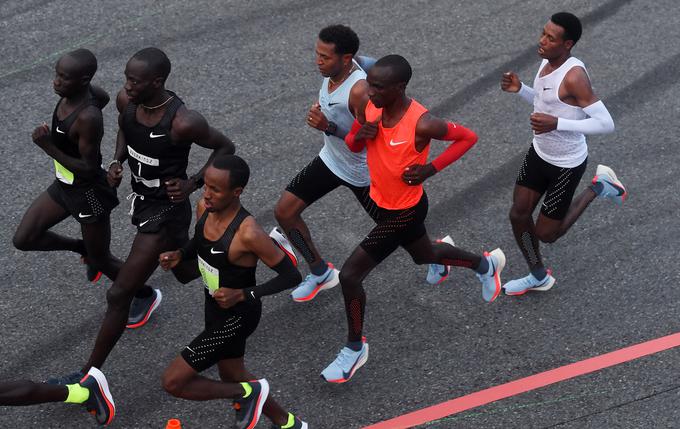 Eliud Kipchoge v rdečem dresu ter Zersenay Tadese in Lelisa Desisa v belih dresih sledita narekovalcem tempa v začetni fazi teka. | Foto: Getty Images