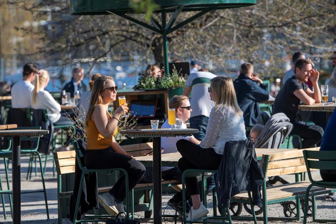 Medtem ko so po Evropi veljali strogi ukrepi, so Švedi živeli skorajda običajno življenje. Na fotografiji so Švedi, ki se družijo v enem od lokalov v Stockholmu aprila letos. Kljub temu, da Švedi niso zapirali nenujnih gospodarskih panog, se niso mogli popolnoma izogniti neprijetnim gospodarskim posledicam, saj so zaradi izvozno usmerjenega gospodarstva zelo odvisni od svetovne trgovine, ki pa je v času pandemija upadla. | Foto: Reuters