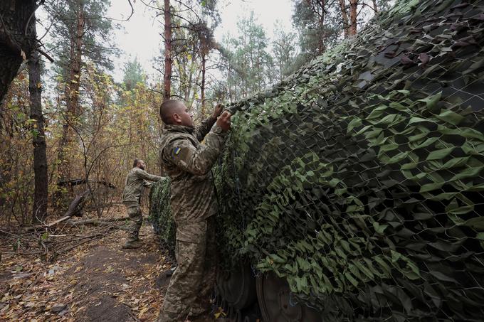 Ukrajinski vojaki pokrivajo samohodno havbico 2S1 Gvozdika z maskirno mrežo na svojem položaju blizu frontne črte sredi ruskega napada na Ukrajino v regiji Harkov. | Foto: Reuters