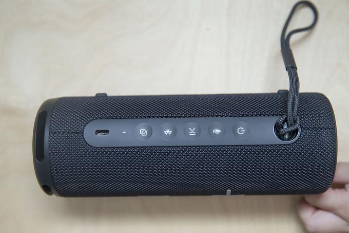 Pet majhnih tipk z osvetljenim ozadjem, ko delujejo, droben LED-indikator delovanja in vhod USB-C za polnjenje se v ležečem položaju zvrstijo ob nosilni vrvici. | Foto: Ana Kovač