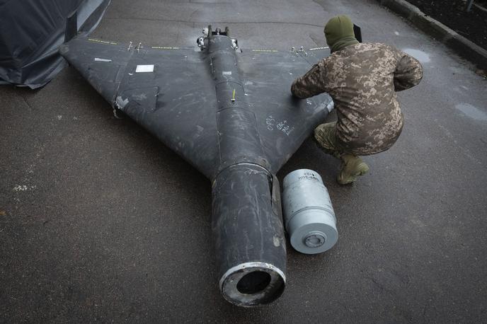 Ukrajinski vojak in ruski dron s termobarično bojno glavo | Rusi naj bi na svoje brezpilotne letalnike dajali tudi termobarične bojne glave. Na fotografiji: ukrajinski častnik novembra letos preiskuje sestreljeni brezpilotni letalnik (gre za iranski dron šahed, ki ga izdeluje tudi Rusija), ki naj bi imel termobarično bojno glavo. | Foto Guliverimage