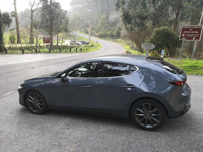 Mazda 3 ob znamenitem in hkrati tragičnem ovinku pri Lagoa Azulu. Mazdini oblikovalci so pri zasnovi zadnjega dela sprejeli pogumno odločitev in na račun linij (streha, zadnja stranska stekla …) žrtvovali velik del uporabnosti te mazde na zadnji klopi in tudi v prtljažniku.  | Foto: Gregor Pavšič