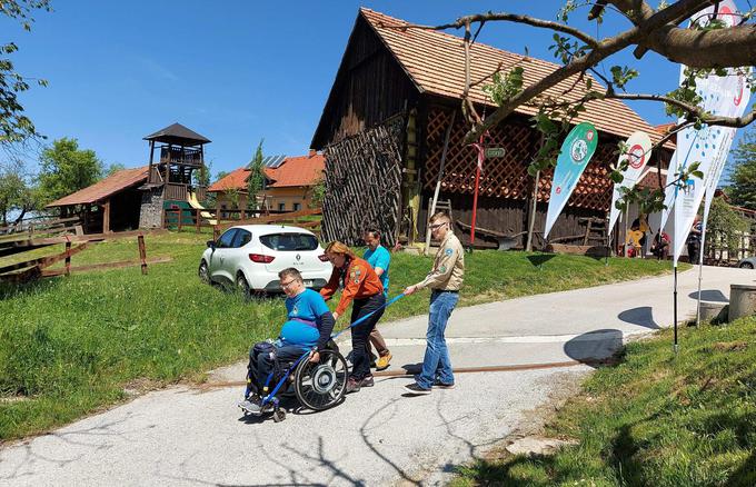 Stojan Rozman, vodja delovne skupine GOGO 2021, je s prostovoljci pokazal, kako z njihovo pomočjo premaguje spuste in vzpone.  | Foto: Alenka Teran Košir