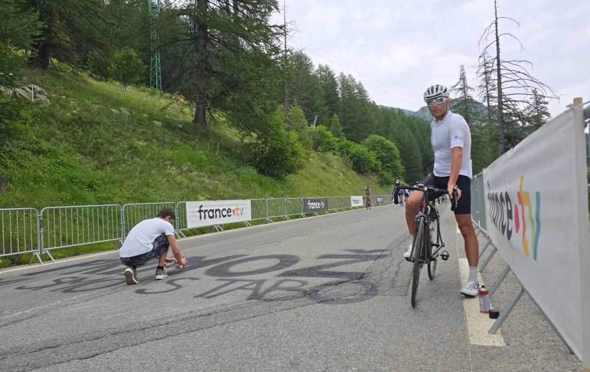 Peter Prevc Tour | Peter Prevc je prvič v življenju na Dirki po Franciji. Po koncu kariere je povedal, da ga bo letos z družino pot ponesla v Alpe, kjer je pričakoval tudi Primoža Rogliča, kar so Prevčevi dali jasno vedeti z napisom na cesti. Zimsko navijaško odpravo je dopolnil še vodja panoge biatlon pri SZS Tomas Globočnik, desno na kolesu. 