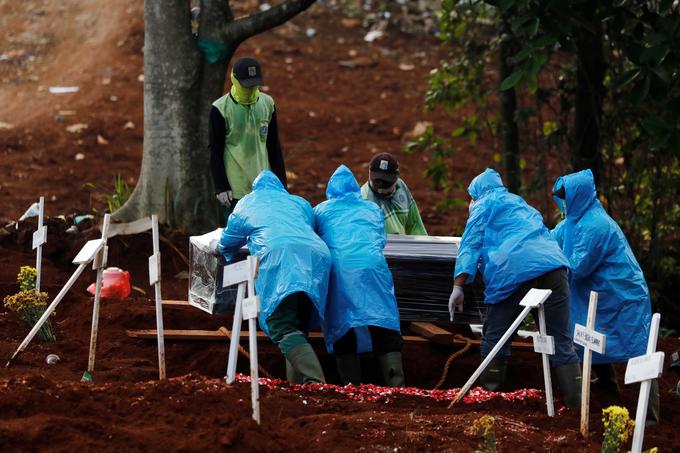 V indonezijski Džakarti kot zaščito pred virusom uporabljajo kar dežne plašče. | Foto: Reuters