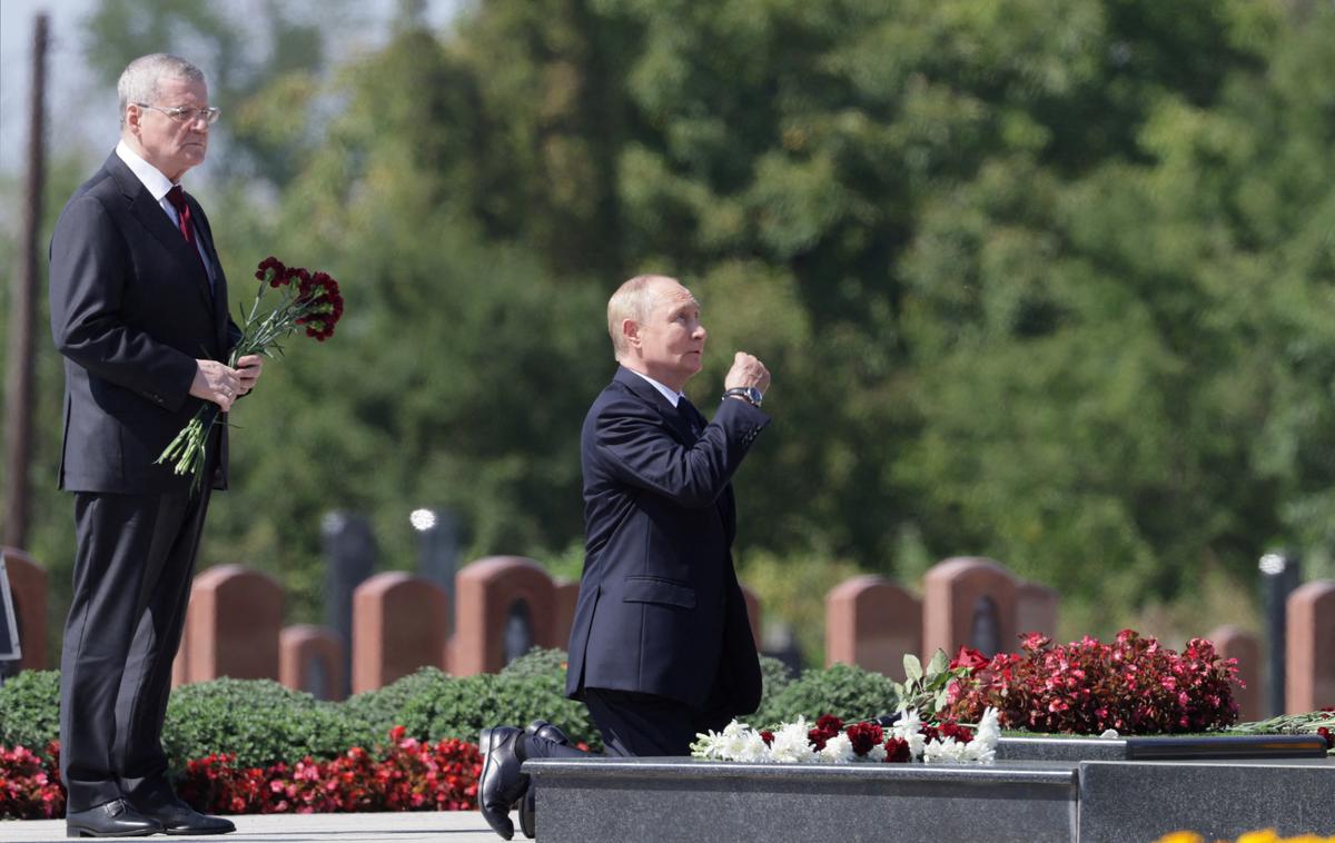 Vladimir Putin v Beslanu | "Predsednik je najprej obiskal pokopališče. Mesto pobitih angelov. Za trenutek je postal pred spomenikom žrtvam pokola v šoli. Nato je tja položil šopek cvetja, pokleknil, bržkone prvič pred tistimi, ki jih je sam poslal v smrt, poljubil marmor, se prekrižal in vstal. Vse skupaj je trajalo manj kot deset sekund." | Foto Reuters