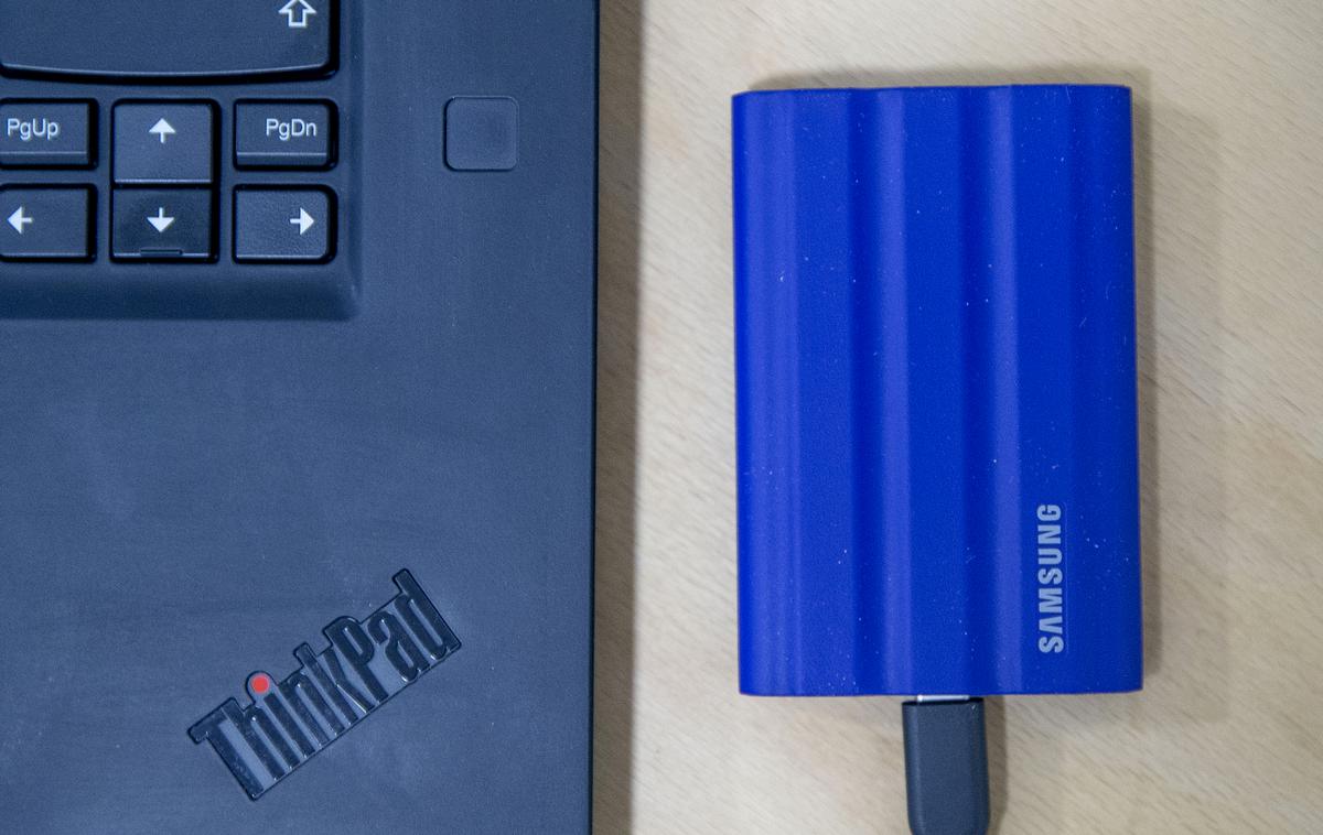 Samsung Portable SSD T7 | Prenosni zunanji disk Samsung Portable SSD T7 Shield – primerjava velikosti s prenosnim računalnikom | Foto Ana Kovač