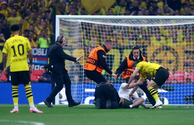 Finale lige prvakov se je začel z "lovom" varnostnikov na gledalca, ki je stekel na igrišče. | Foto: Reuters