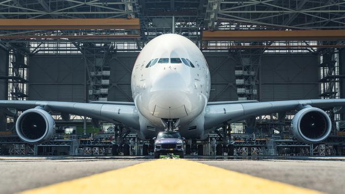 Porsche cayenne je velikana potegnil iz velikega vzdrževalnega hangarja družbe Air France, ki je za podvig pod budnim očesom letalskih inženirjev in tehnikov pripravila enega izmed svojih desetih airbusov A380. Gre za šest hektarjev oziroma 60 tisoč kvadratnih metrov veliko tehnično dvorano, zgrajeno posebej za vzdrževanje flote airbusov A380, v katero bi lahko parkirali kar 3.000 takih cayennov. | Foto: Porsche