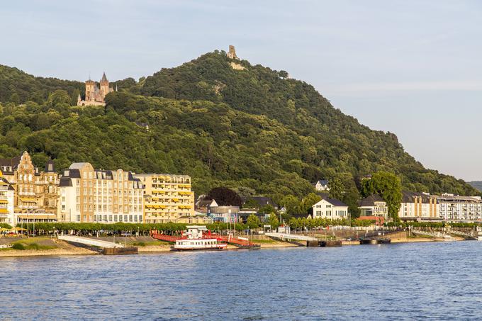 Na fotografiji je mesto Königswinter ob Renu. Nad mestom je hrib Drachenfels, ki je velika turistična zanimivost. Na vrhu hriba so ruševine gradu, malce nižje je dvorec. V bližini Königswinterja je tudi Petersberg, na katerem stoji istoimenski hotel. V tem hotelu je bil po drugi svetovni vojni sedež zavezniške visoke komisije, tukaj je bil leta 1949 podpisan sporazum, ki je tlakoval pot ustanovitvi Zahodne Nemčije. Na drugi strani Rena, nasproti Königswinterja, leži mesto Bad Godesberg. Tukaj je imela leta 1959 stranka SPD kongres, na katerem se je dokončno odpovedala marksizmu in odpravi kapitalizma. Nedaleč od Bad Godesberga je Bonn, nekdanja prestolnica Zahodne Nemčije. | Foto: Guliverimage/Vladimir Fedorenko