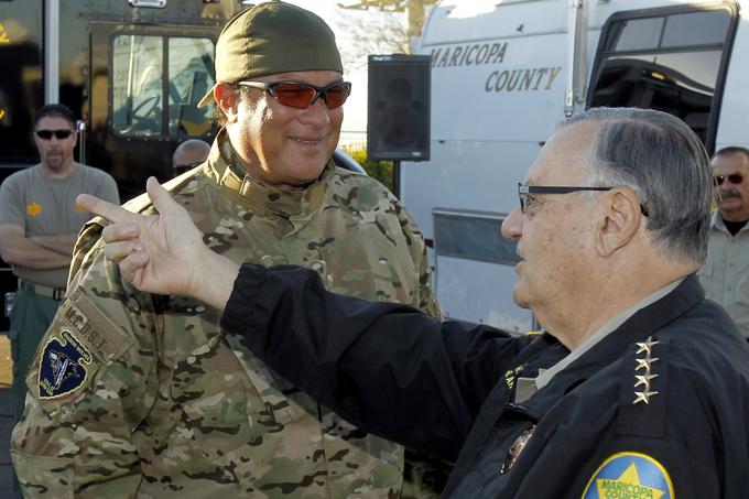 Steven Seagal je svoj poklic policista vzel zelo resno. Leta 2010 ga je hollywoodska zvezdnica Jessica Alba med pogovorom označila za filmskega igralca, a jo je popravil, da ni igralec, temveč predstavnik roke zakona. Takrat sta skupaj snemala film Mačeta. Na fotografiji je v družbi nekdanjega šerifa v okrožju Maricopa v ameriški zvezni državi Arizoni Joeja Arpaija, samooklicanega najstrožjega šerifa v ZDA, ki je zaslovel s svojim neizprosnim pristopom do nezakonitih migracij in predvsem s številnimi obtožbami, da se požvižga na človeške pravice oziroma pravice ameriških državljanov.  | Foto: AP / Guliverimage