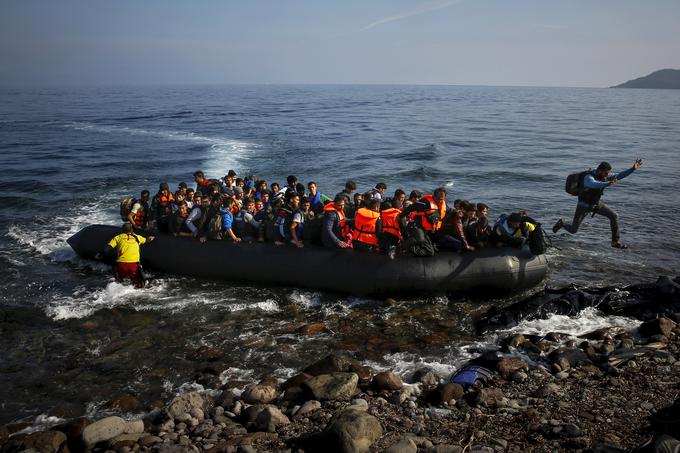 Afganistanski migrant skače s prenatrpanega čolna na plažo grškega otoka Lezbos, 19. oktober 2015. | Foto: Reuters