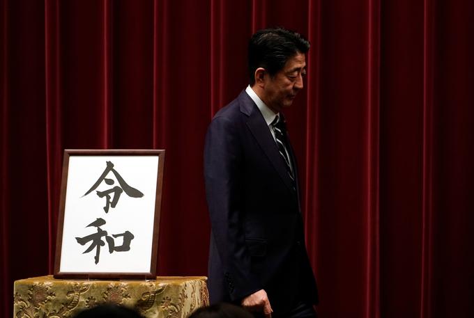 Japonski premier Shinzo Abe na predstavitvi novega obdobja. Za njim sta pismenki, ki sestavljata besedo Reiwa. | Foto: Reuters