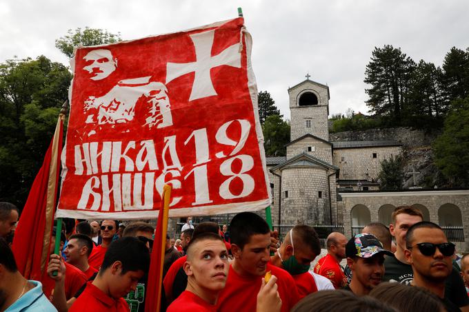 Črnogorska nacionalna čustva so najmočnejša v Cetinju in njegovi okolici. Na tem območju se je konec 17. stoletja oblikovala od Turkov dejansko neodvisna pravoslavna teokratska državica. Mednarodno priznana je postala na berlinskem kongresu leta 1878. Leta 1910 je postala kraljevina. Leta 1918, ko je Črno goro vojaško zasedla srbska vojska, je tako imenovana podgoriška skupščina razglasila priključitev k Srbiji. Ta odločitev je travma za črnogorske zagovornike neodvisnosti od Srbije. Po letošnjih volitvah, ko je Đukanovićev blok strank izgubil večino, so bili na Cetinju protesti (na fotografiji). Eden od protestnikov nosi rdečo zastavo z napisom v cirilici, ki se v slovenščini glasi Nikdar več 1918. Na zastavi je tudi podoba Krsta Popovića, vojaškega voditelja upora proti priključitvi k Srbiji. Prav zaradi strahu pred ponovitvijo leta 1918 se je pred dnevi odhajajoča črnogorska vlada tako jezno odzvala na besede srbskega veleposlanika v Črni gori Vladimirja Božovića, ki je javno zagovarjal odločitev podgoriške skupščine o priključitvi k Srbiji. | Foto: Reuters