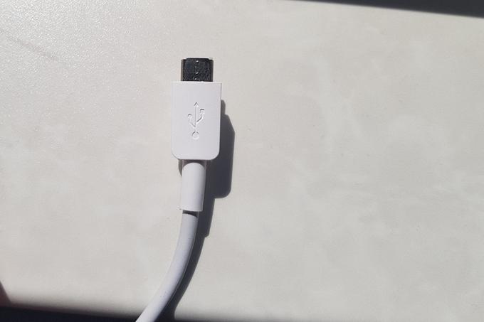 Avtor tega prispevka je zaradi odsotnosti podpore USB-C takoj imel dodatno delo z iskanjem ustreznega kabla (oziroma odpakiranjem priloženega na fotografiji),saj ima pod delovno mizo dva polnilnika USB-C in nobenega micro USB.  | Foto: Matic Tomšič