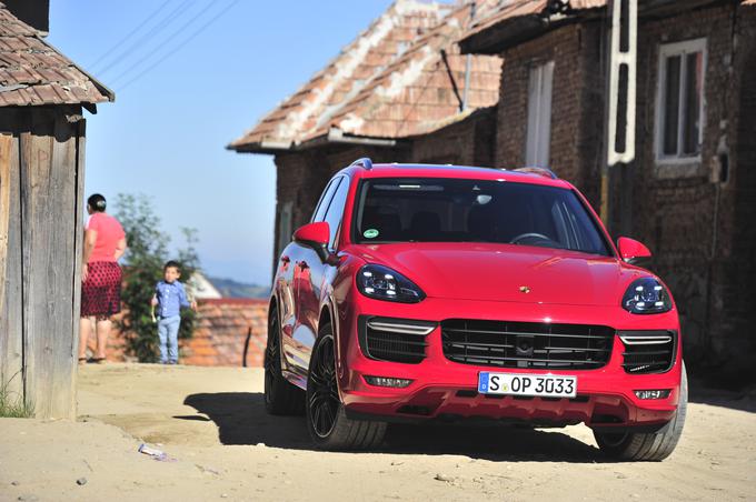 Rdeči porsche cayenne GTS prevladuje v privabljanju pozornosti v eni od romunskih vasic. Ciril Komotar pripravlja video reportažo o dveh Porschejevih težkokategornikih in njunih soočenjih z romunskimi cestami in dvema prelazoma, ki ju strokovnjaki z avtomobilističnega področja štejejo med najlepša na svetu. | Foto: Siol.net/ A. P. K.