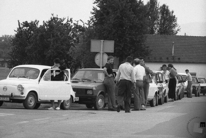 Vozni park na naših cestah je pred 25 leti predvsem bil vezan na avtomobilsko industrijo nekdanje Jugoslavije. Golfi iz Sarajeva (TAS), katrce (renault 4) iz IMV-ja oziroma današnjega Revoza, opli iz Kikinde, pa seveda modeli stoenka, yugo, 128 … Crvene zastave iz Kragujevca. Pasivna in aktivna varnost v teh modelih je bila praktično nična. To so bili časi, ko nekateri tovrstni avtomobili niso imeli niti vzglavnikov, nikakršnih namenskih karoserijskih ojačitev, ni bilo ABS zavor, pa zračnih blazin in tudi testov agencije Euro NCAP še ne. To so bili tudi časi, ko se je nemalokrat čakalo na gorivo. Fotografija posneta v času vojne za Slovenijo v okolici Ljubljane. Foto: Nace Bizilj, hrani Muzej novejše zgodovine Slovenije. | Foto: Nace Bizilj, hrani Muzej novejše zgodovine Slovenije