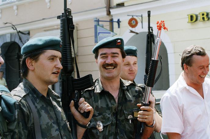 Slovenski teritorialci leta 1991 | Po nekaj dnevih ofenzive jugoslovanske vojske se je v osamosvojitveni vojni razmerje moči na bojiščih začelo obračati v korist Slovenije. Na fotografiji: veseli pripadniki slovenske Teritorialne obrambe 6. julija 1991, ko je Slovenija že zmagovala v vojni. | Foto Guliverimage