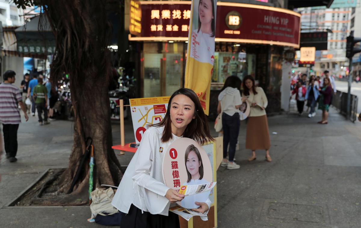 HongKong | Prebivalka Hongkonga z volilnim plakatom ene od kandidatk. | Foto Reuters