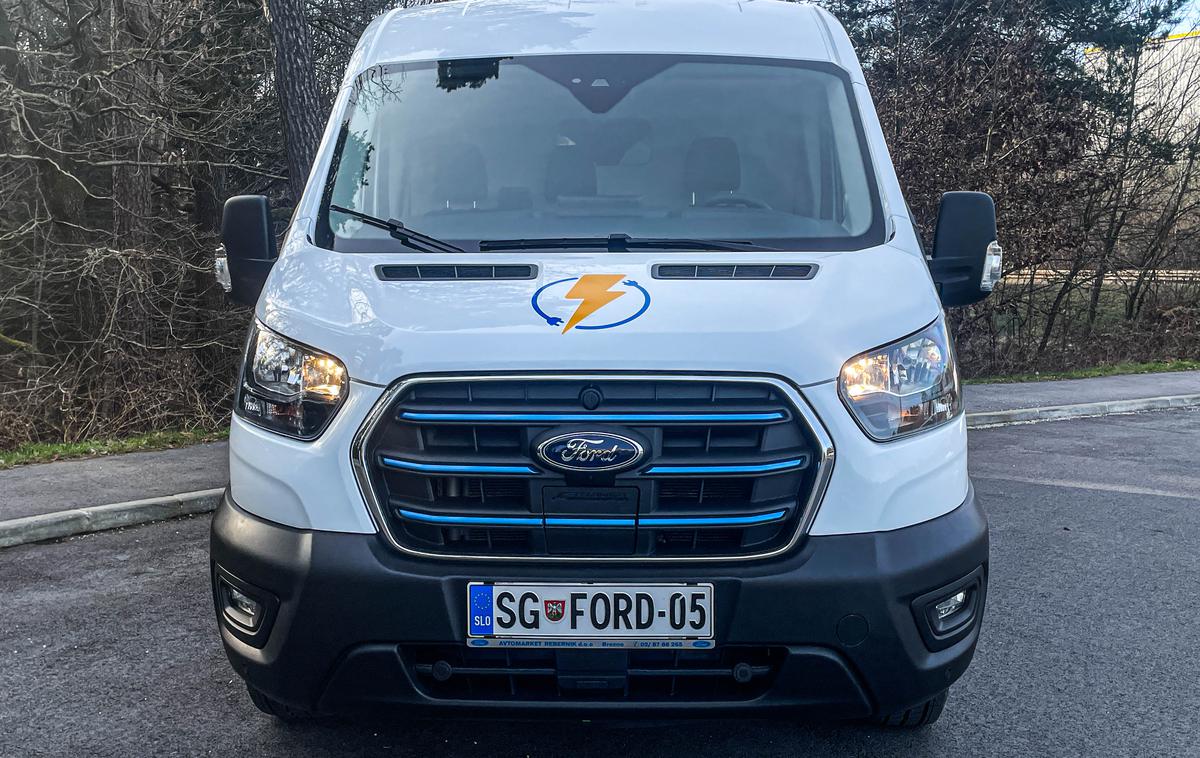 Ford e-transit | Pravzaprav se e-transit od transita z motorjem na notranje zgorevanje vizualno ne razlikuje. Le na maski hladilnika ima tri modre črte in lepo skrito polnilno mesto. | Foto Gašper Pirman