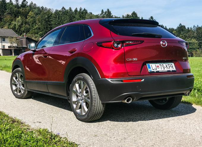 Serijski CX-30 ima radarski tempomat, samodejno prilaganje snopa žarometov, žaromete LED, nadzor voznikove zbranosti, opozorilo nad vozili v mrtvem kotu, opozarjanje pred prečnim prometom, prepoznavanje prometnih znakov, prepoznavanje pešcev, samodejno zaviranje, zadnje parkirne senzorje, digitalne merilnike, navigacijo in zdaj tudi podporo za vmesnika Car Play oziroma Android Auto. Med serijskimi elementi ni vzvratne kamere, samodejne klimatske naprave in matričnih žarometov LED.   | Foto: Gašper Pirman