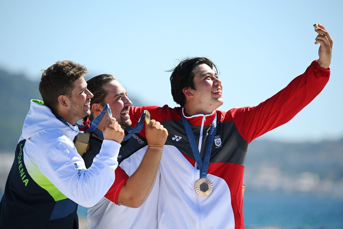 Dobitnik srebrne medalje Toni Vodišek iz slovenske ekipe, dobitnik zlate medalje Valentin Bontus iz avstrijske ekipe in dobitnik bronaste medalje Maximilian Maeder iz ekipe Singapurja pri ustvarjanju zmagovalnega selfija s telefonom Samsung Galaxy Z Flip6 Olympic Edition na podelitvi medalj v moškem formula kitu na štirinajsti dan olimpijskih iger Pariz 2024 v marini Marseille 9. avgusta 2024 v Marseillu v Franciji. | Foto: Clive Mason / Getty Images