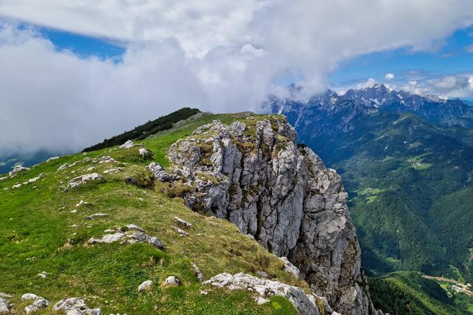 Pogled proti nadaljevanju grebena Raduhe, za njo pa so v oblakih v smeri zahoda Dleskoškova planota, Ojstrica in drugi vrhovi KSA. | Foto: Matej Podgoršek