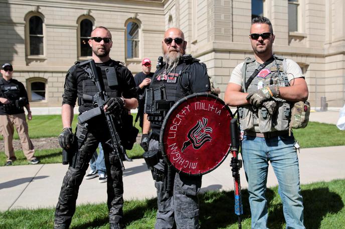 Pripadniki michiganske milice | V zvezni državi Michigan na predsedniških volitvah ponavadi zmagujejo demokratski kandidati. Toda to je le zaradi velikih modrih mest, kot je Detroit, saj je podeželje globoko rdeče. Na fotografiji vidimo tri do zob oborožene republikancem naklonjene michiganske milice, ki so se letos septembra v michiganski prestolnici Lansing zbrali v podporo pravici do nošenja orožja. | Foto Reuters