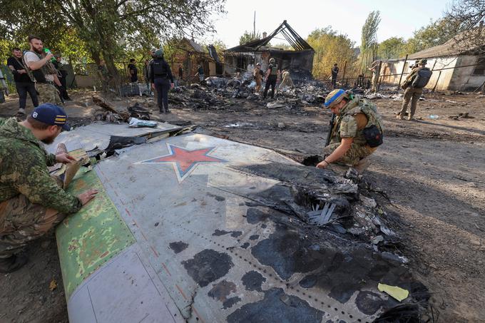 5. oktober: ukrajinski vojaki preiskujejo razbitine brezpilotnega letala Suhoj S-70 Okhotnik-B, ki je po sestrelitvi padlo 16 kilometrov onkraj frontne črte na neokupirano ozemlje Ukrajine.  | Foto: Reuters