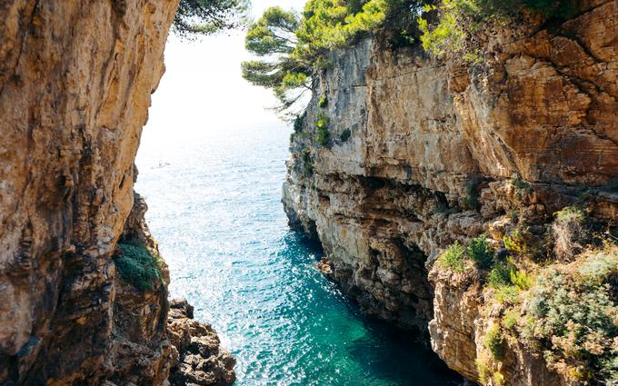 Morski kanjon z visokimi strmimi pečinami, ki se spuščajo do turkizne vode. Mesto za skok v kanjonu Verudela, južno od Pulja. | Foto: Shutterstock