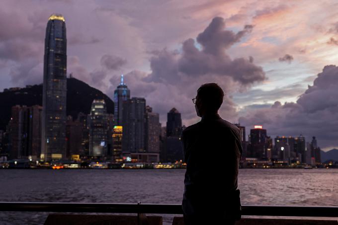 Moški pred pristaniščem Victoria Harbour, v ozadju osrednje finančno okrožje v Hongkongu | Foto: Reuters