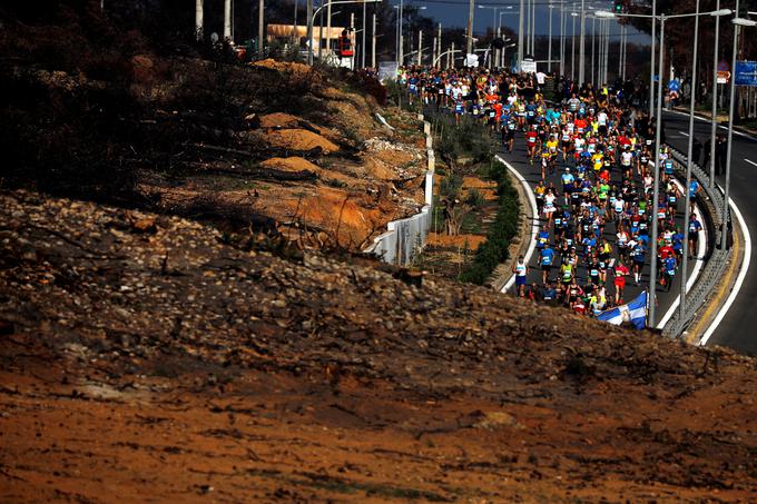 11. november: tekači med 36. atenskim maratonom tečejo mimo hriba, ki ga je požgal obsežen julijski požar. | Foto: Reuters